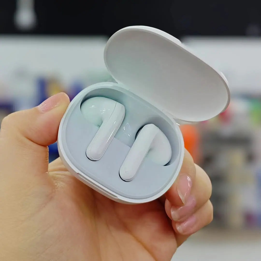 Redmi Buds 4 Lite con estuche abierto sobre madera